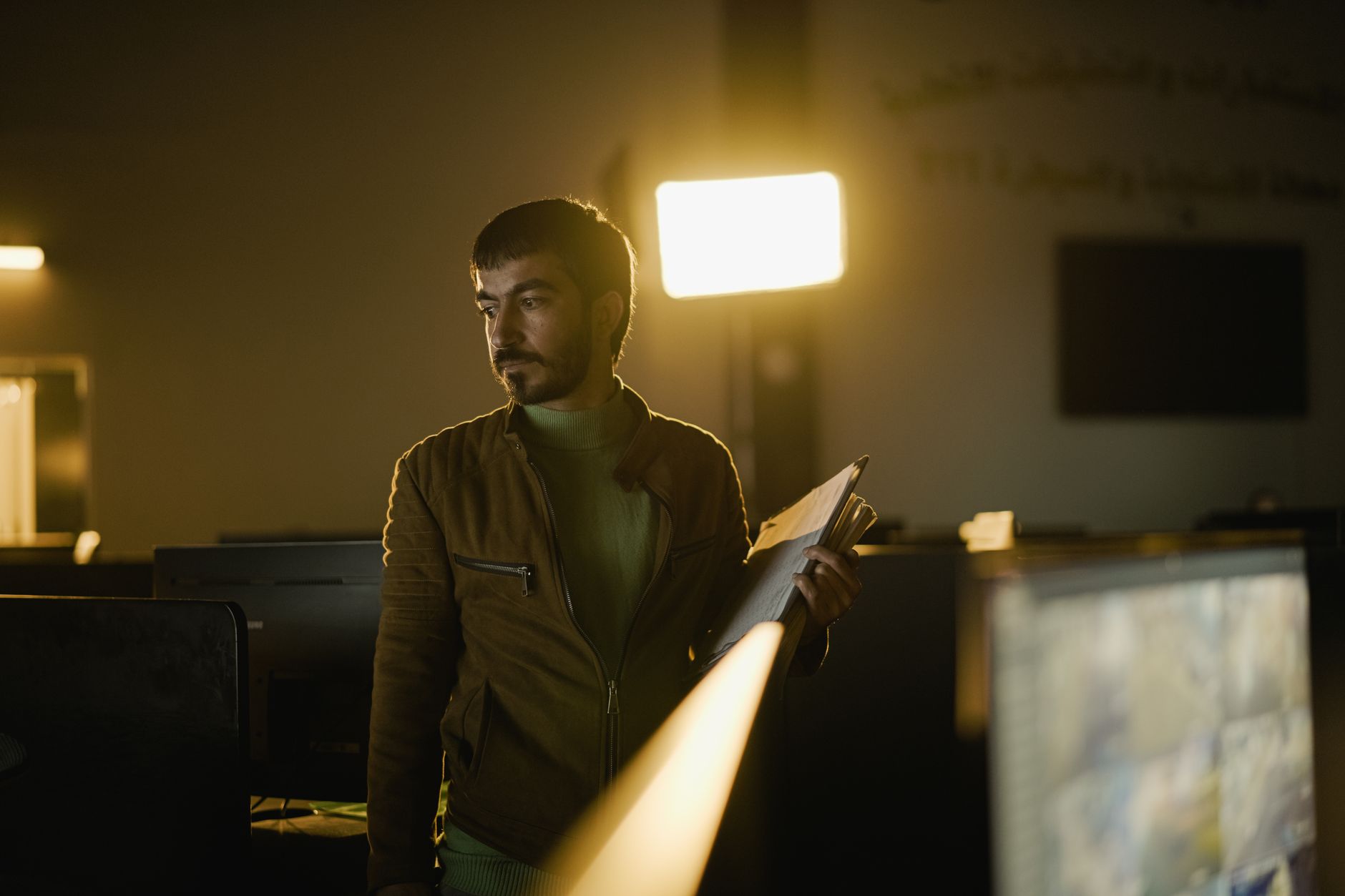 A person looking at photo file properties on a laptop screen while holding a printed photo