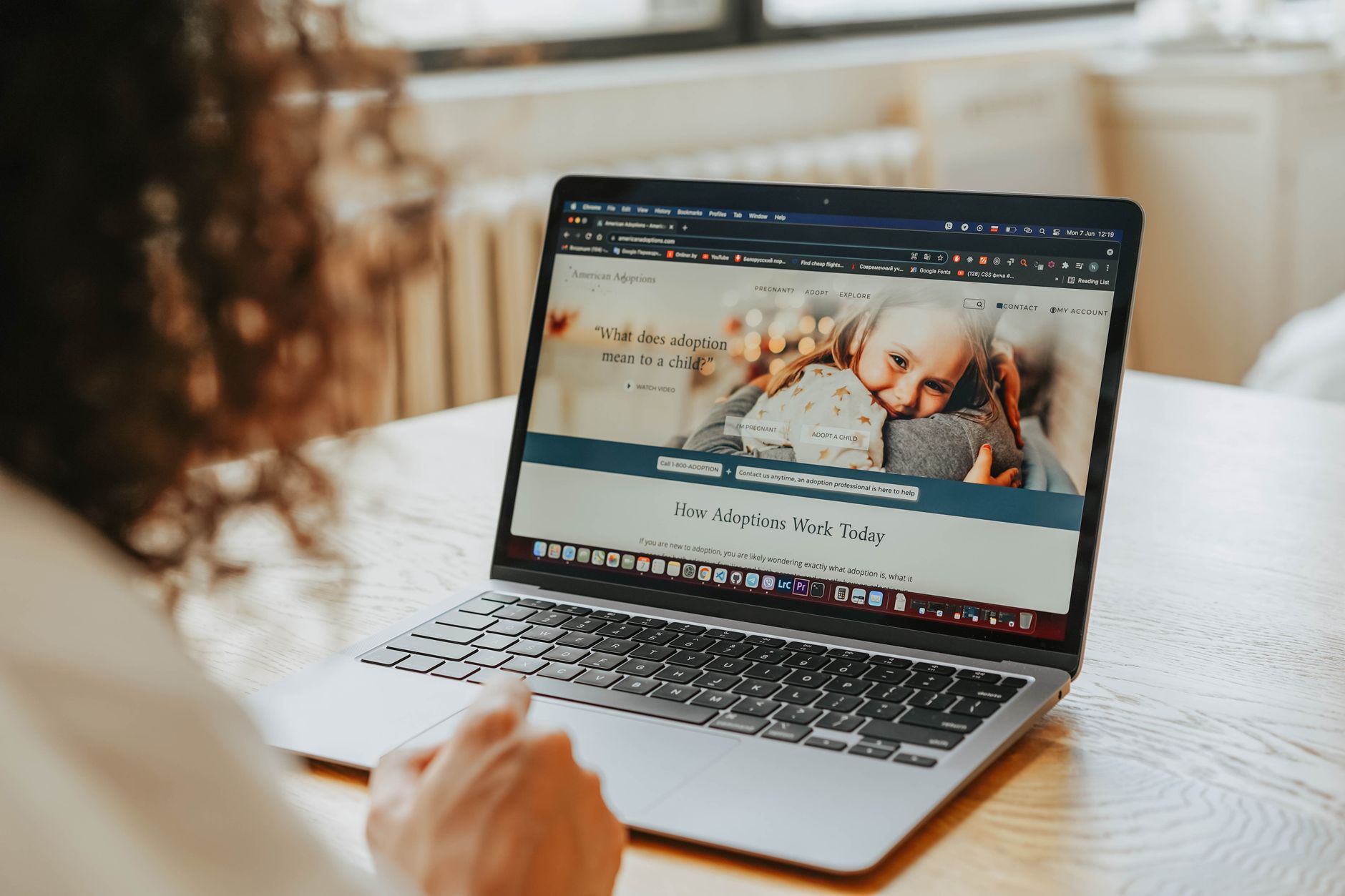 Person looking at a website's contact page on a laptop, checking for ownership details.