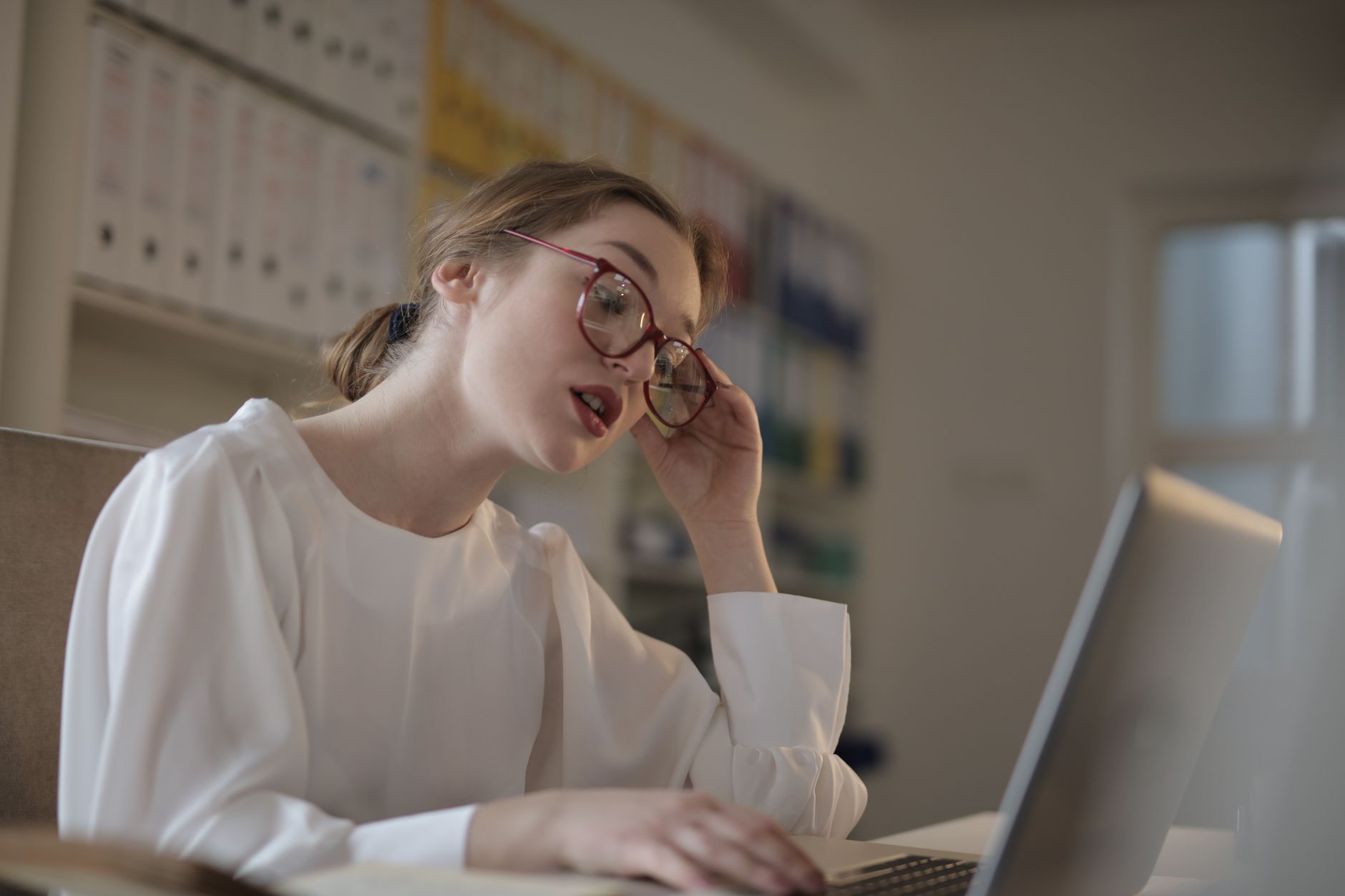 Person reading website comments on a laptop with a skeptical expression.