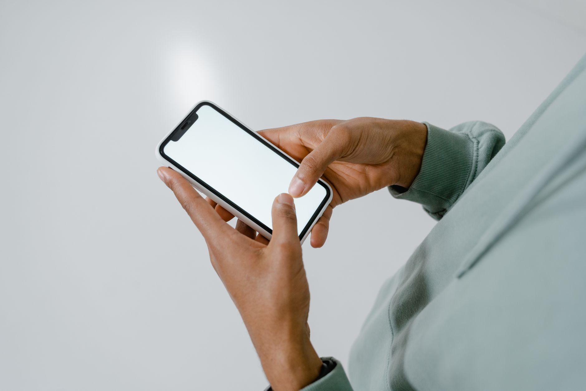 Close up of a hand holding a smartphone showing a six-digit authentication code on the screen.