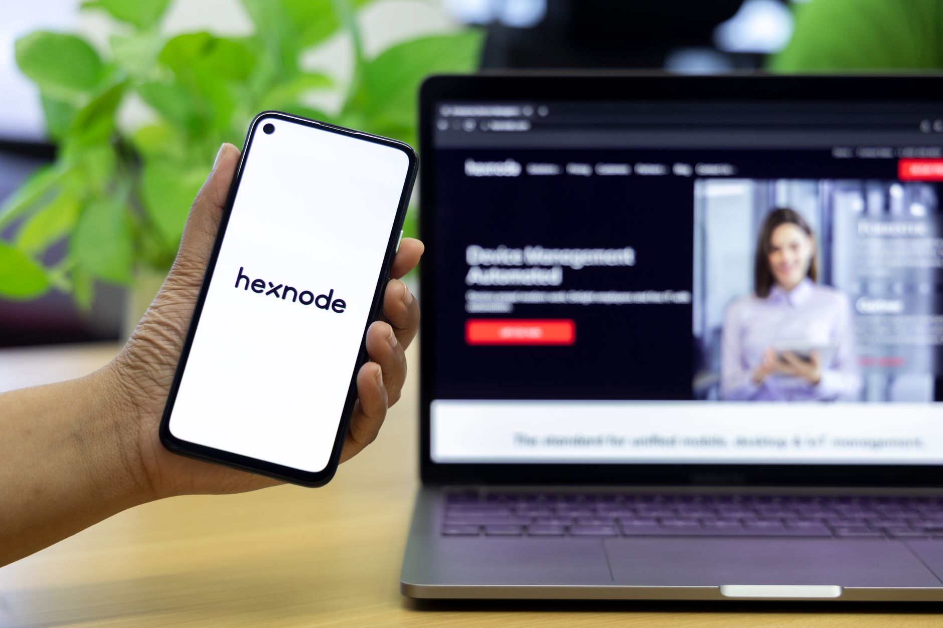 A person holds a smartphone displaying a two-factor authentication app with six-digit codes.